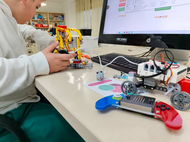 Estudiante programando un brazo robótico